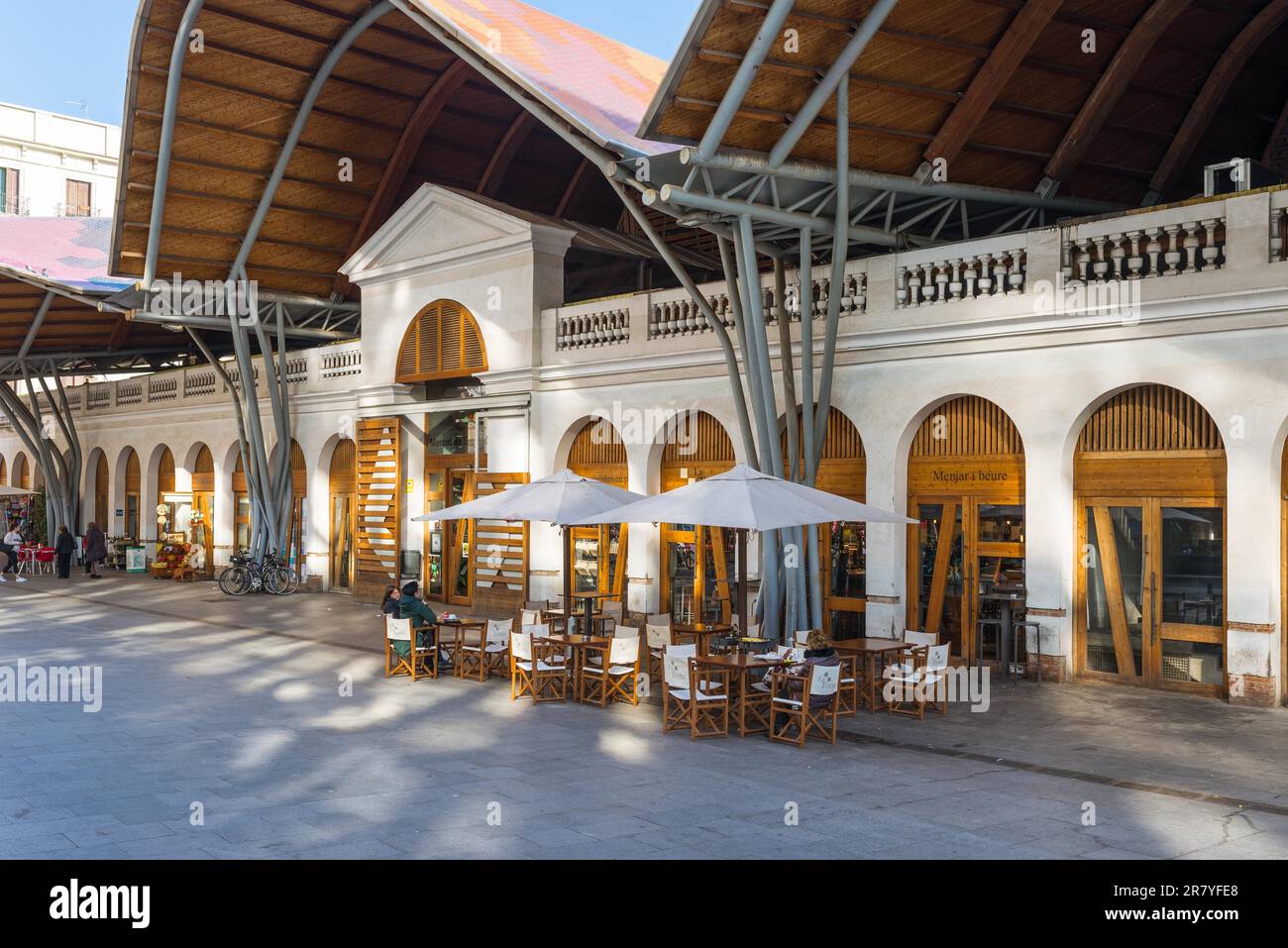 Front side of the public market Mercat de Santa Caterina in Barcelona. Guests have lunch in the Tapas bar. The market has a nice colorful curved Stock Photo