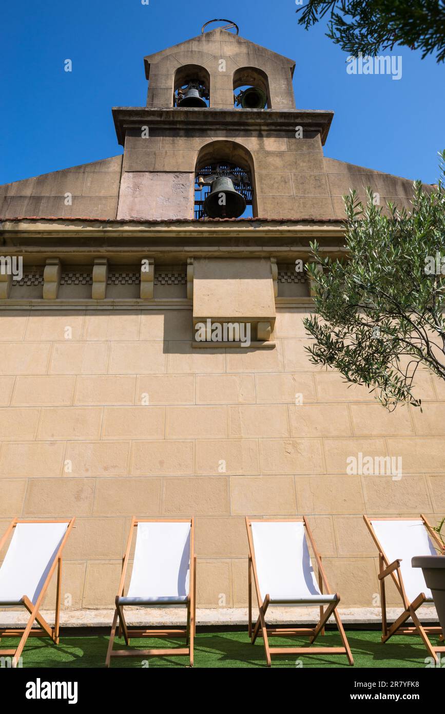 Deckchairs under Bell gable with three bells on a church in Donostia