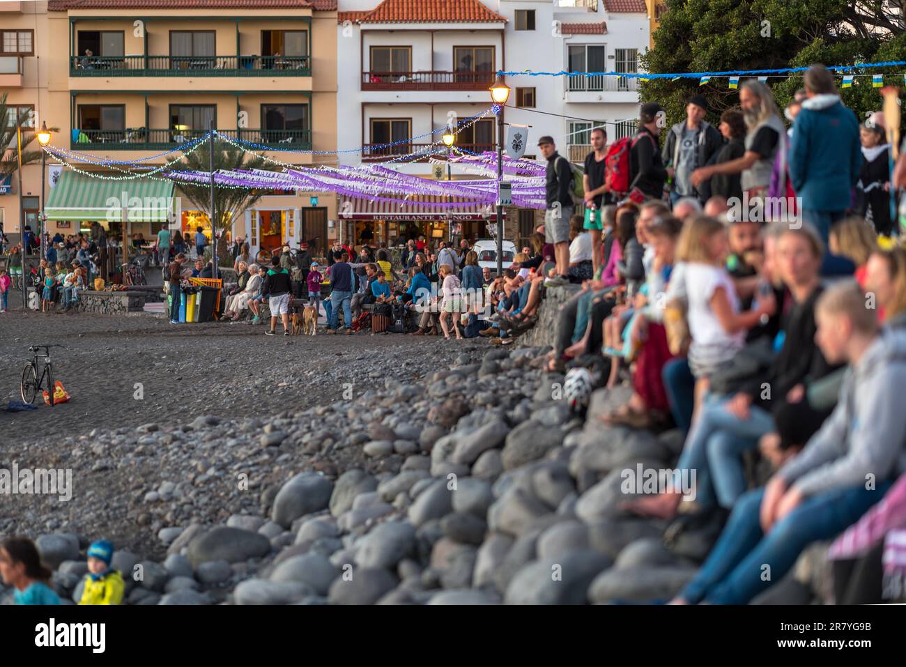 People celebrate an old Hippie culture, sitting at the beach at sundown, with music, dance and fire performance Stock Photo