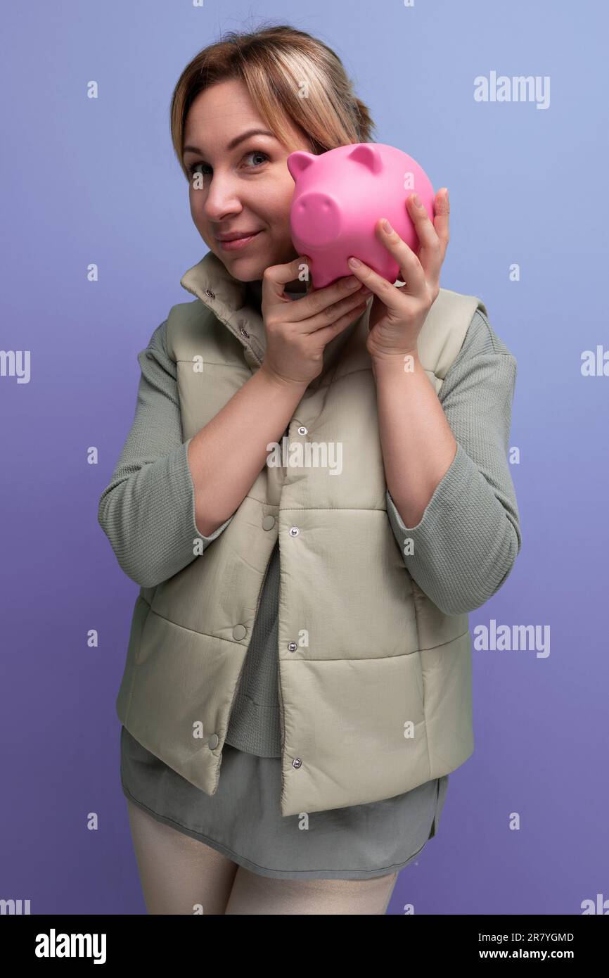 young blond hair woman keeps savings in a piggy bank Stock Photo - Alamy