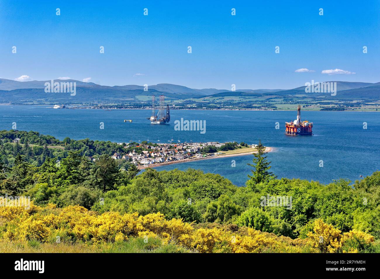 Cromarty Scotland Cromarty Firth blue sky and a view over the town the houses and orange oil rig towards the hills in early summer Stock Photo