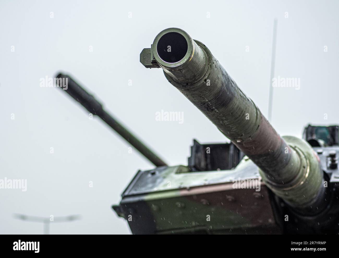 Armoured tank Leopard and howitzer Panzerhaubitze 2000 or PzH 2000 with the cannons aimed at the sky under the rain during the Ukrainian attack Stock Photo