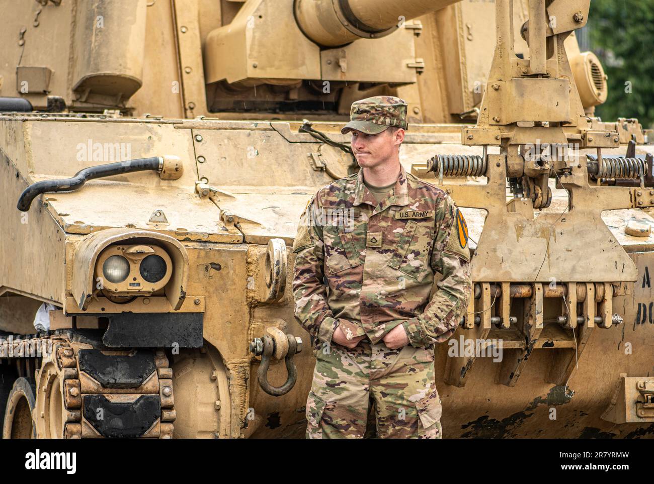 American United States Marine Corps soldier standing under the rain near an Abrams armoured tank, NATO response force Stock Photo