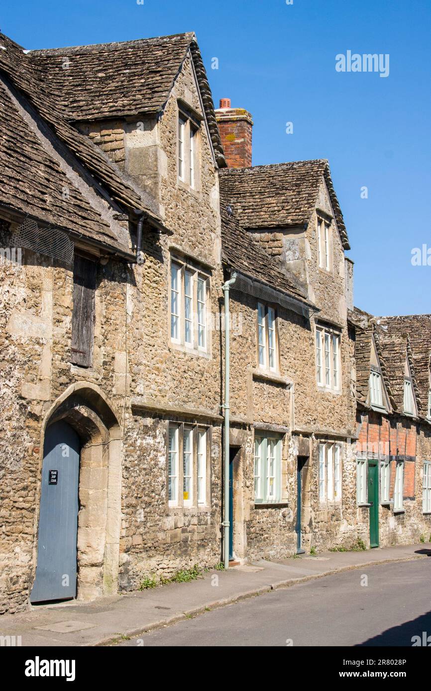 View along Church Street, 15th century - 18th century typical Cotswold stone houses in the picturesque Cotswold village of Lacock. Blue sky. Stock Photo