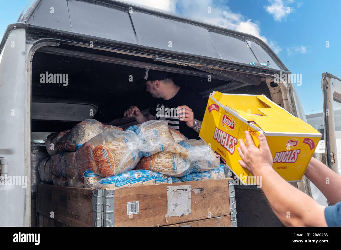 RIVNE, UKRAINE  - JUNE 18, 2023. Unloading humanitarian aid to Ukraine. Ukrainian volunteers unloading boxes with humanitarian aid Stock Photo