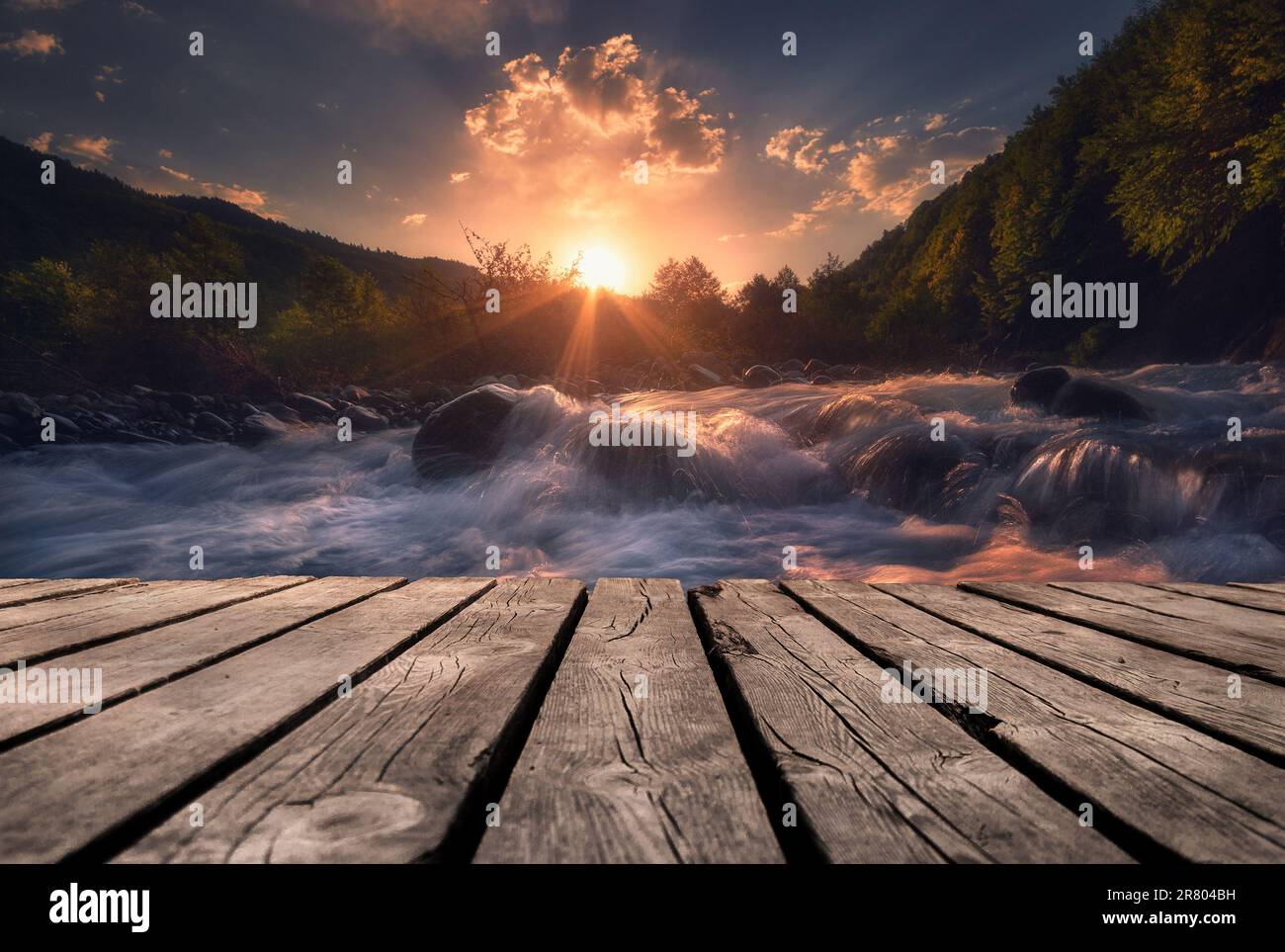Fast mountain river flowing In sunset time with empty wooden batten ...
