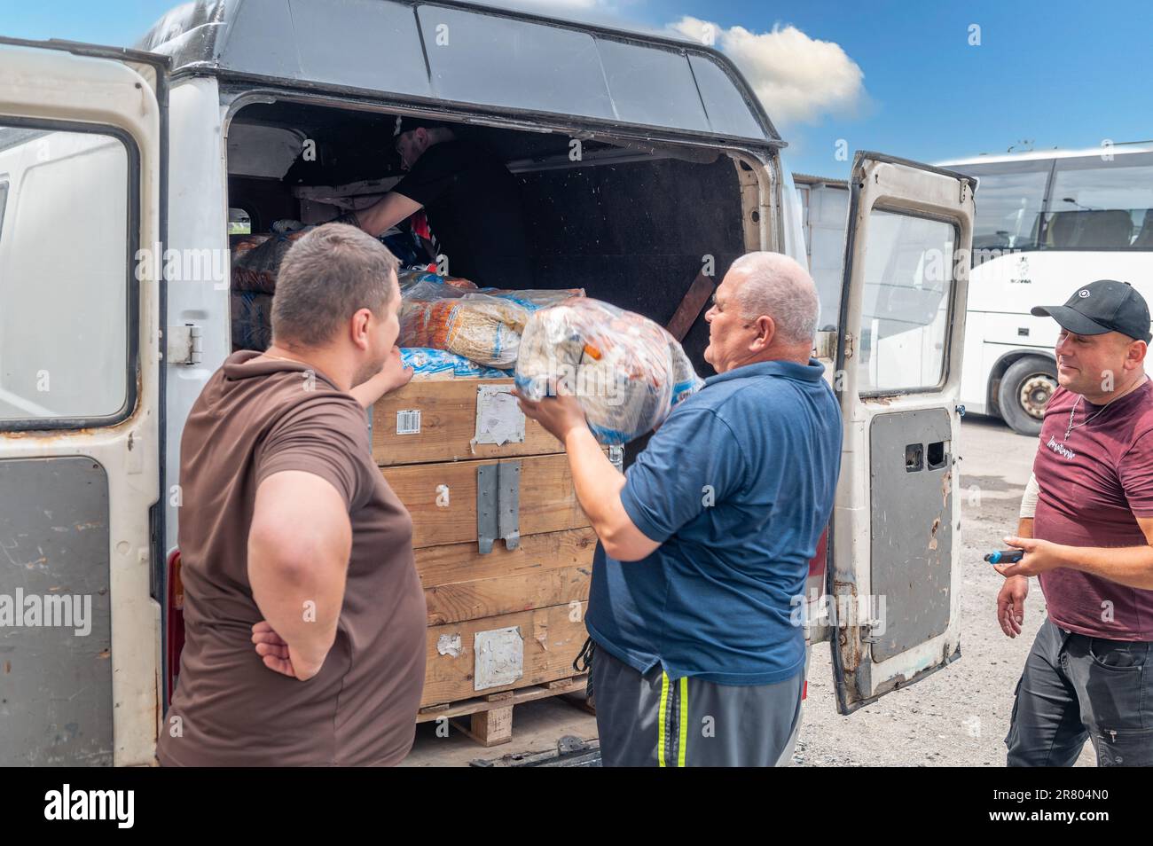 RIVNE, UKRAINE  - JUNE 18, 2023. Unloading humanitarian aid to Ukraine. Ukrainian volunteers unloading boxes with humanitarian aid Stock Photo