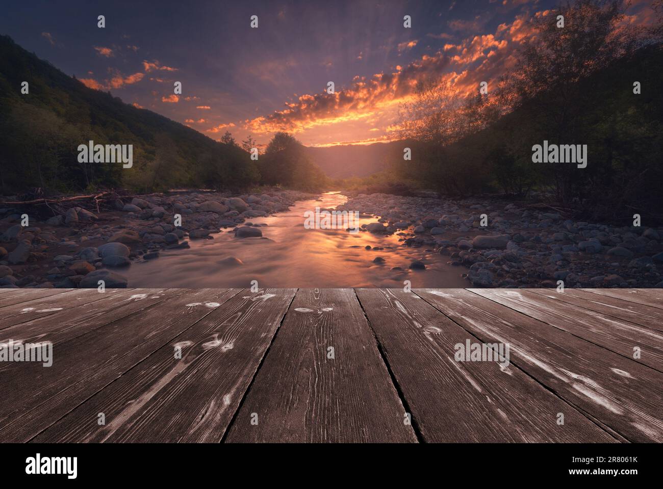 Fast mountain river flowing with empty wooden batten bridge. Natural ...