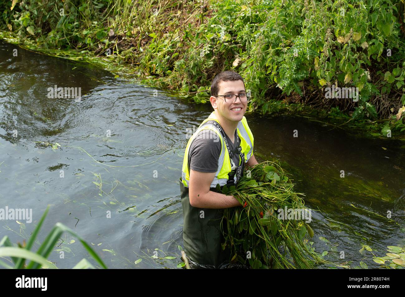 Eton Wick, UK. 18th June, 2023. Local residents and volunteers from the Eton Wick Waterways Group near Windsor in Berkshire who are supported by Thames 21, were clearing weeds from Boveney Ditch in Eton Wick today so as to improve the flow of water in the waterway. They work to conserve and protect  the natural environment and wildlife surrounding the Eton Wick waterways. Joining them to clear the weeds were newly elected Windsor, Eton and Eton Wick Liberal Democrats Councillors, Devon Davies (pictured) and Mark Wilson. Frank O’Kelly a Councillor from nearby Slough also joined the clear up. Et Stock Photo