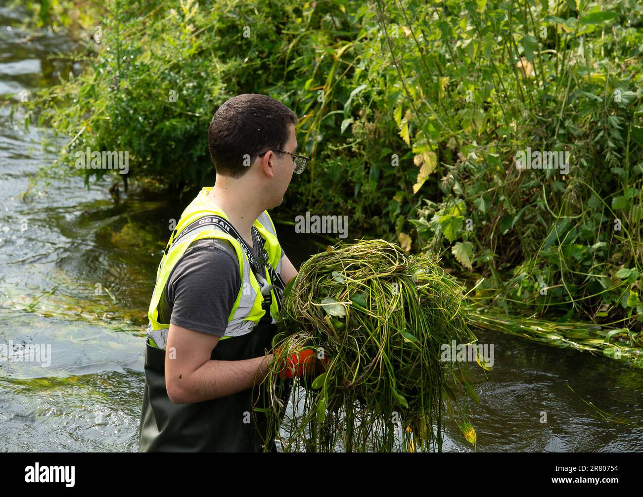 Eton Wick, UK. 18th June, 2023. Local residents and volunteers from the Eton Wick Waterways Group near Windsor in Berkshire who are supported by Thames 21, were clearing weeds from Boveney Ditch in Eton Wick today so as to improve the flow of water in the waterway. They work to conserve and protect  the natural environment and wildlife surrounding the Eton Wick waterways. Joining them to clear the weeds were newly elected Windsor, Eton and Eton Wick Liberal Democrats Councillors, Devon Davies (pictured) and Mark Wilson. Frank O’Kelly a Councillor from nearby Slough also joined the clear up. Et Stock Photo