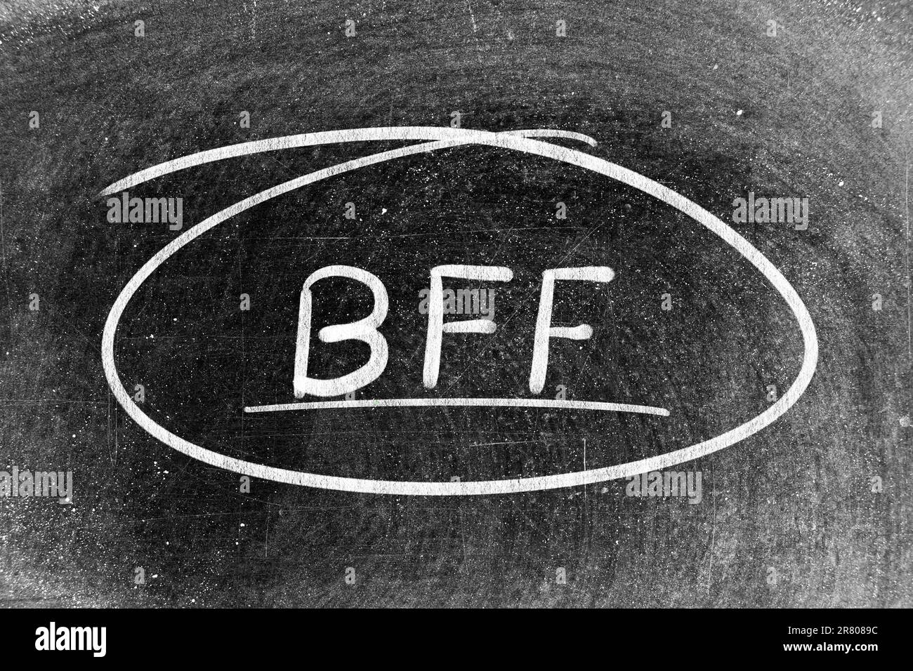 White chalk hand writing in word BFF (Abbreviation of best friend forever) and circle shape on