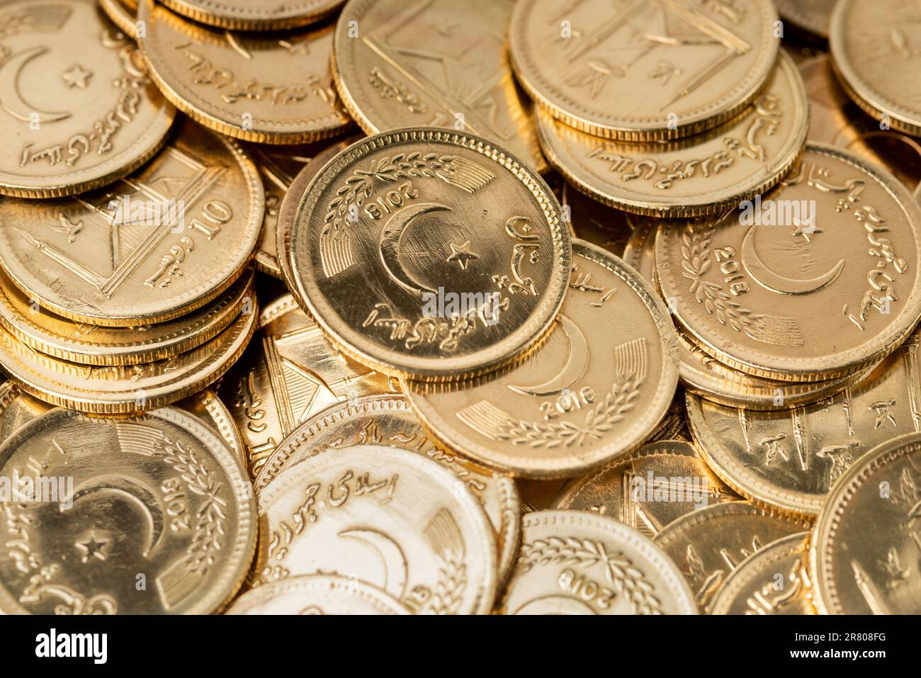 Stacks of gold coins of Pakistani currency symbolize wealth and