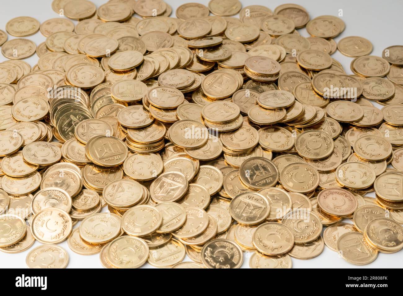 Stacks of gold coins of Pakistani currency symbolize wealth and