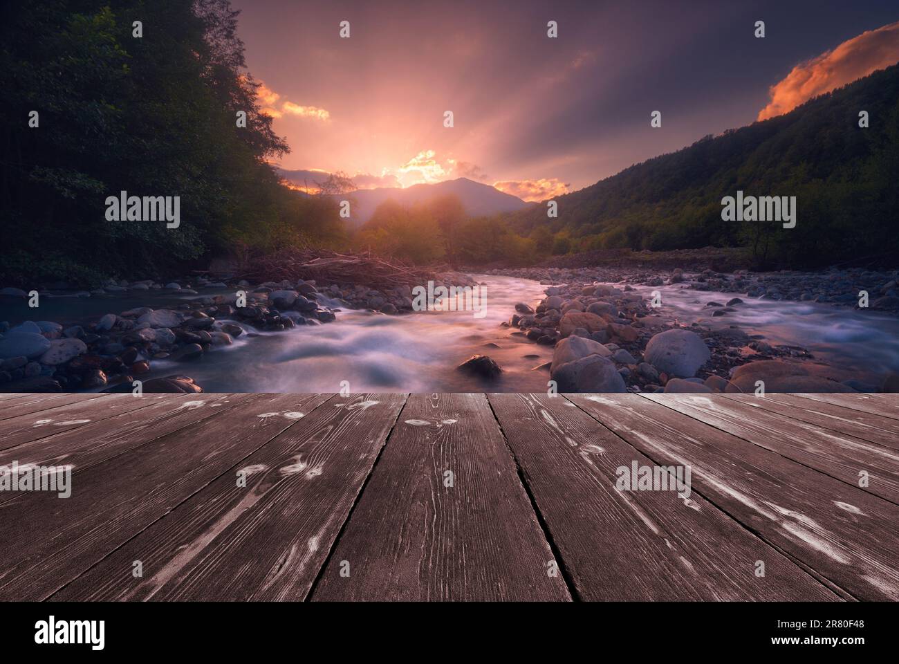 Fast mountain river flowing with empty wooden batten bridge. Natural ...
