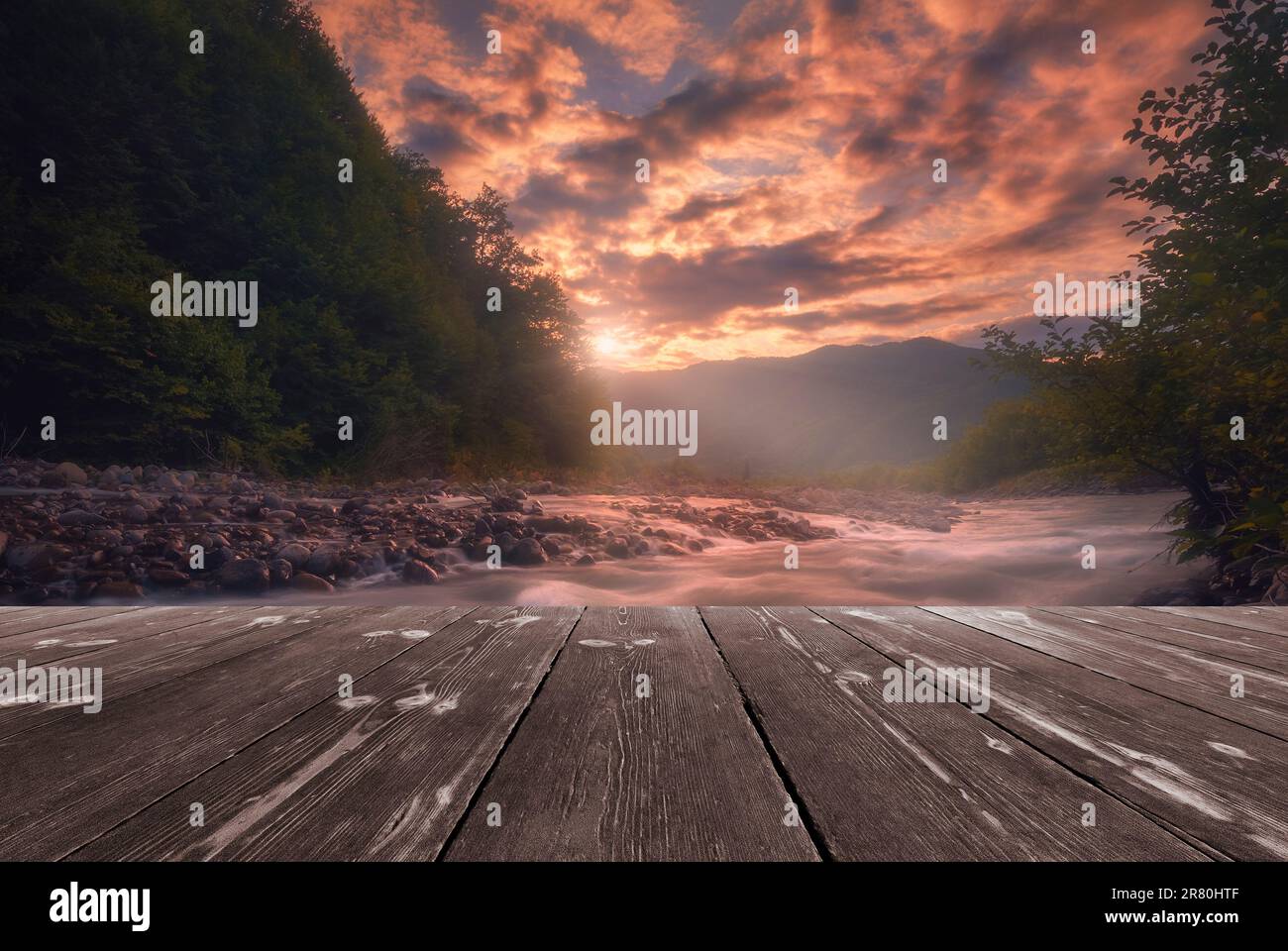 Fast mountain river flowing with empty wooden batten bridge. Natural ...