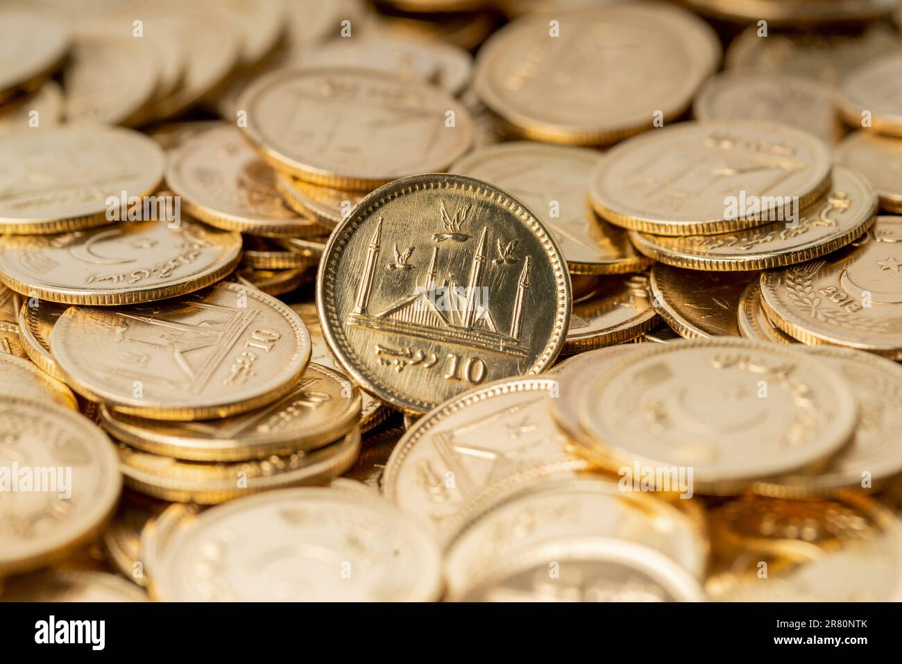 Stacks of gold coins of Pakistani currency symbolize wealth and