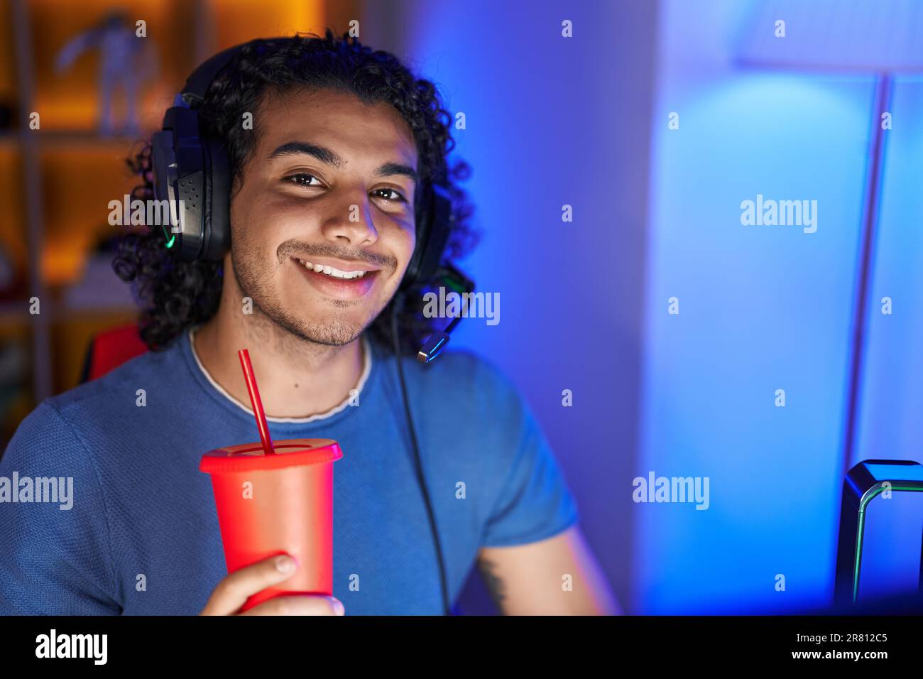 Young latin man streamer smiling confident drinking beverage at gaming ...