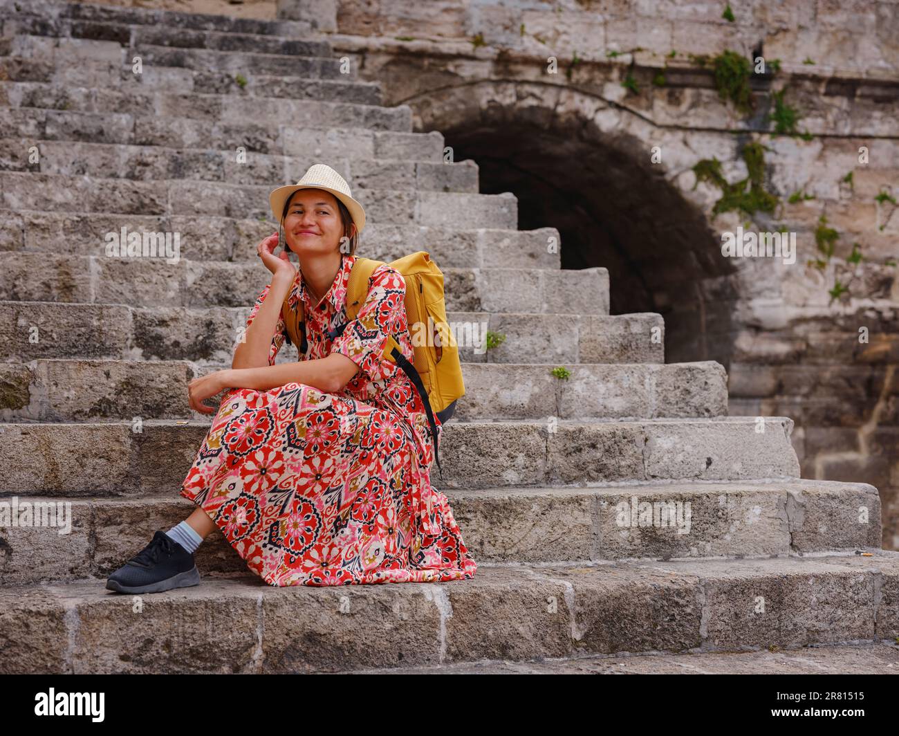 Rhoades Steps Young Asian woman in red dress walks through streets of Rhodes. woman ...