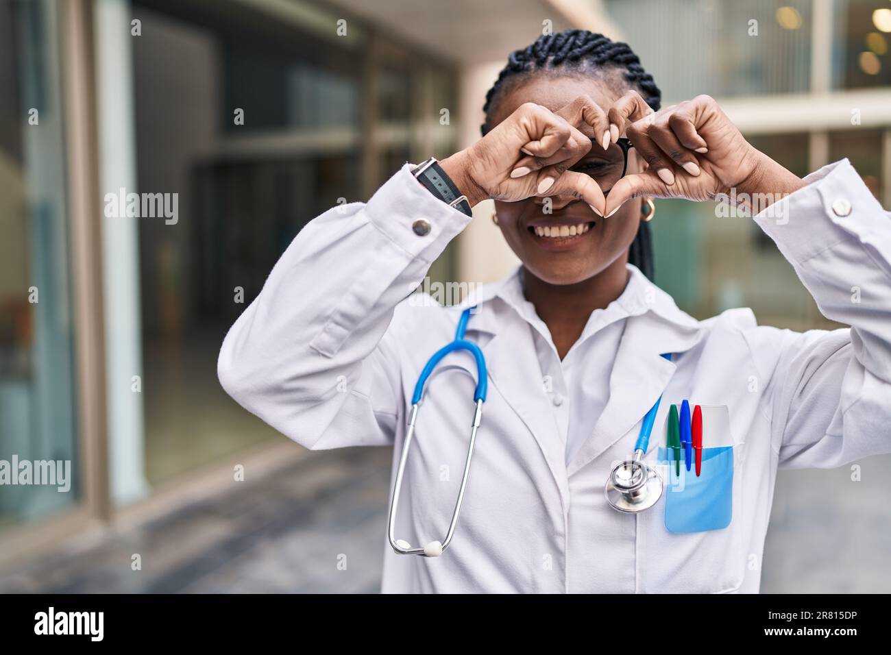 African american woman doctor smiling confident doing heart gesture ...
