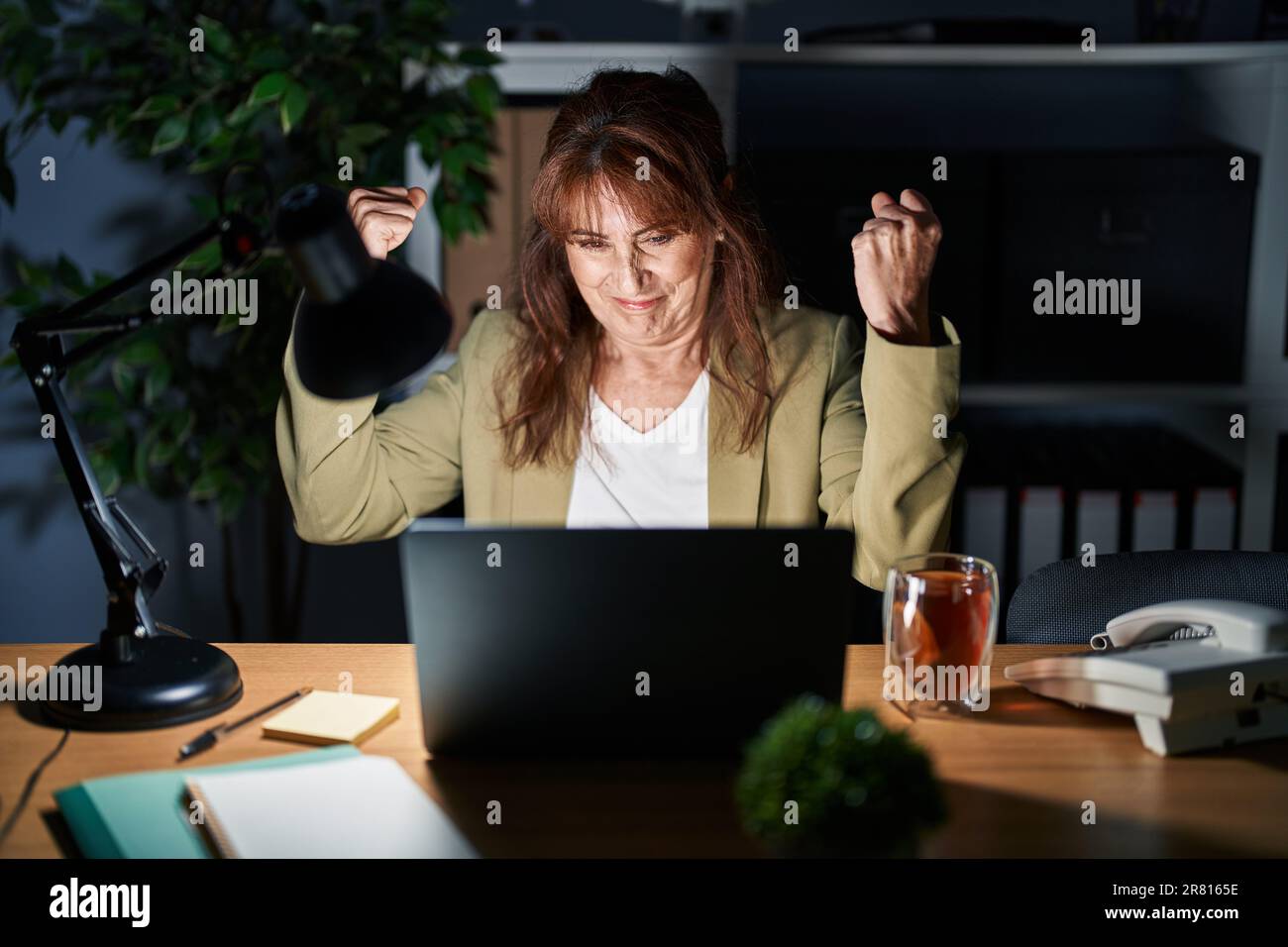Middle age hispanic woman working using computer laptop at night ...