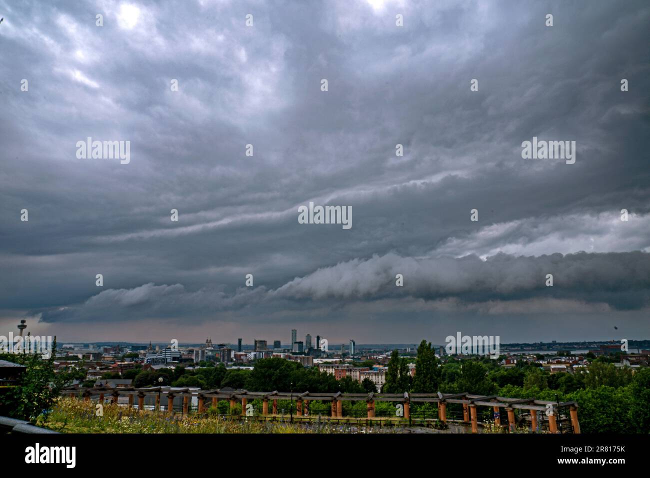 Storm clouds roll in over the city of Liverpool, Merseyside. More than half a month's worth of rain could fall in parts of the UK over the next 24 hours, along with thunder, lightning and possible flooding, forecasters at the Met Office have said. Picture date: Sunday June 18, 2023. Stock Photo