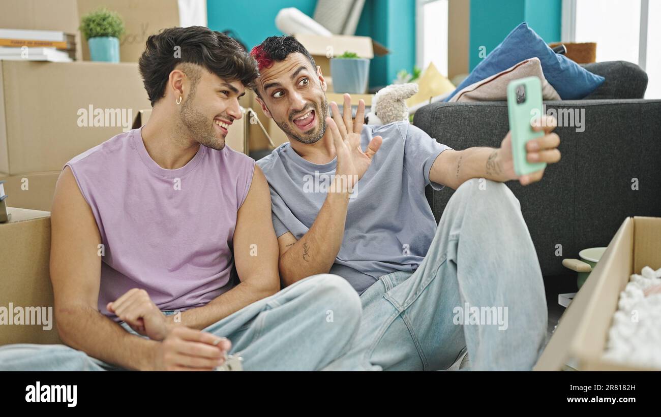 Two men couple holding keys having video call at new home Stock Photo ...