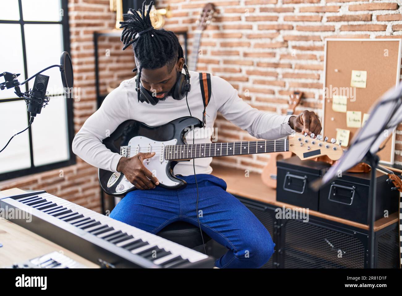African American Woman Artist Playing Electrical Guitar At Music Studio african-american-woman-artist-playing-electrical-guitar-at-music-studio