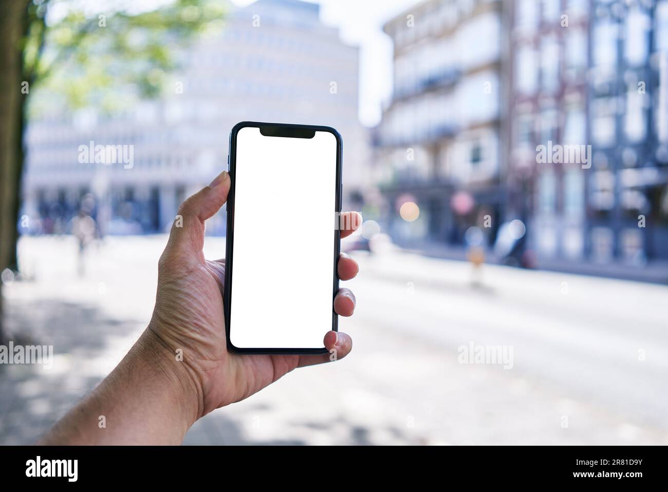 Man holding smartphone showing white blank screen at amsterdam Stock Photo  - Alamy
