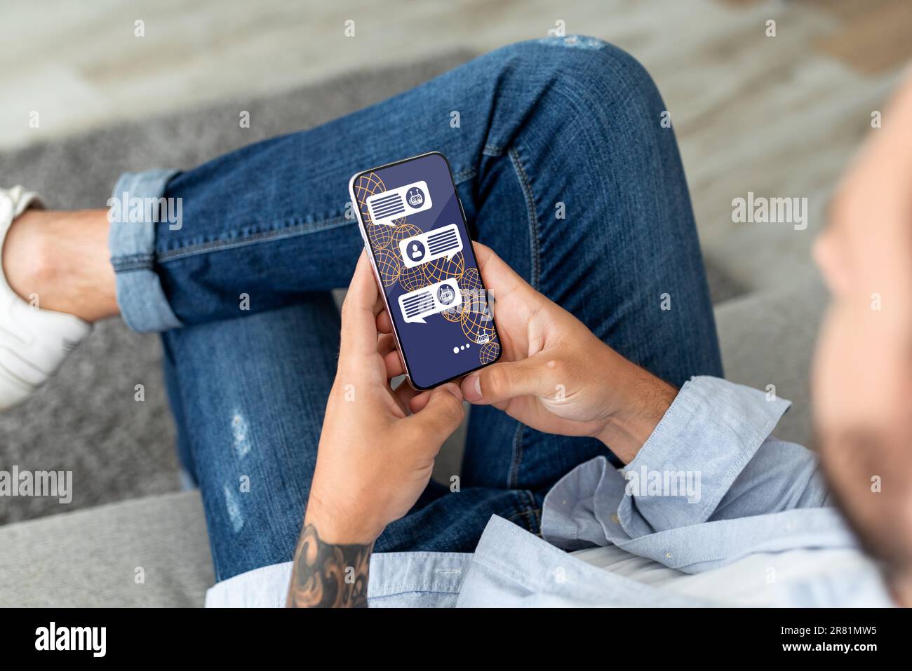 Cropped of stylish man sitting outdoors, using AI on smartphone Stock Photo