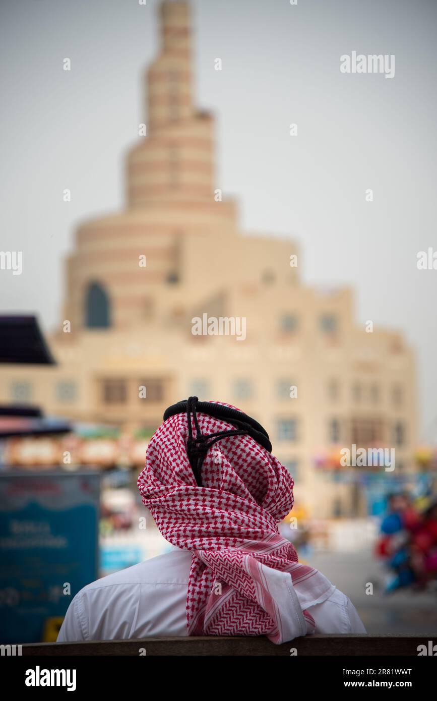 Backside  view of men in its cultural headdress facing al Fanar at Doha Qatar Stock Photo