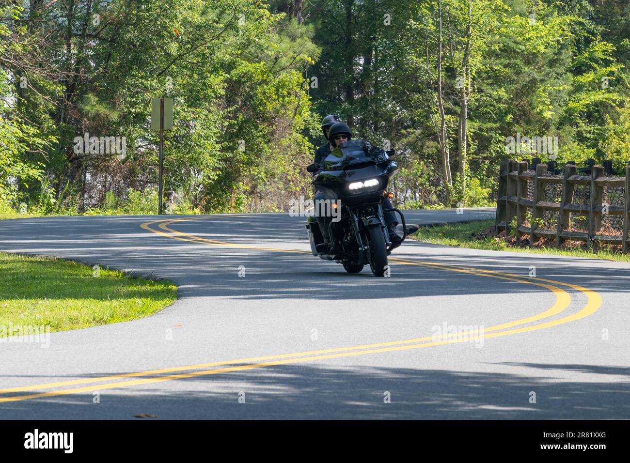 black hog motorcycle with headlights on driving winding mountain road motion Stock Photo Alamy