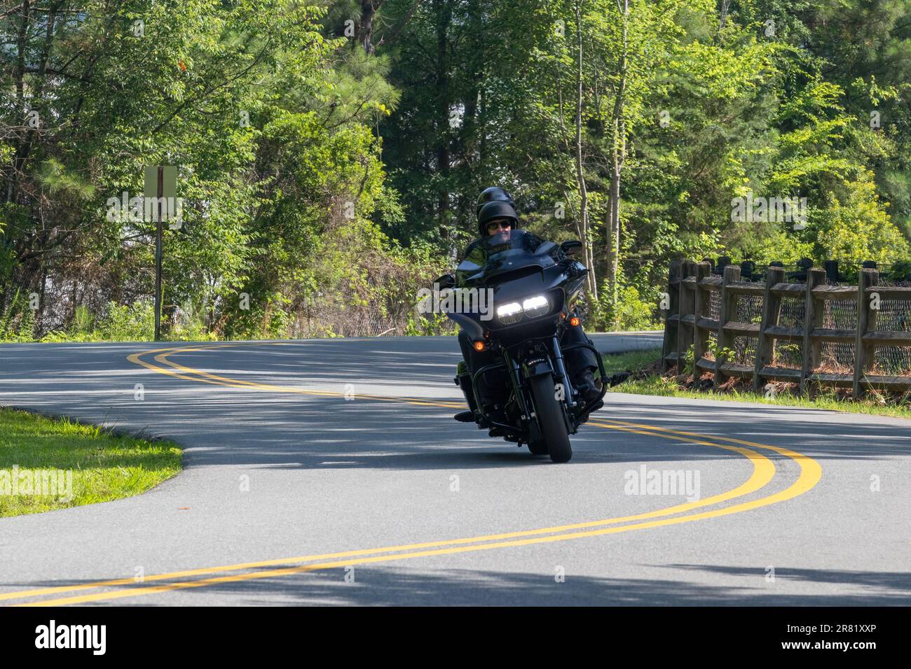 black hog motorcycle with headlights on driving winding mountain road Stock Photo Alamy