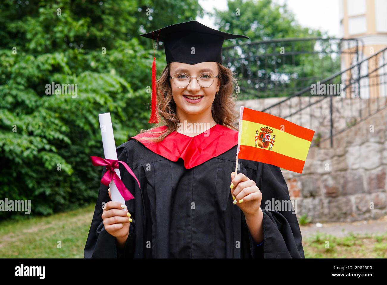Young spanish girl wearing graduation gown and hat holding flag of Spain  smiling happy and positive Stock Photo - Alamy