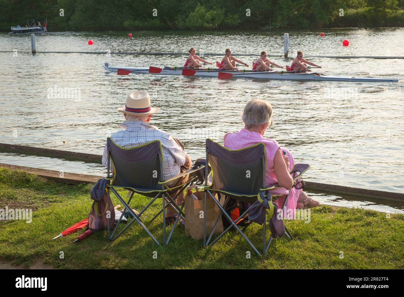 A couple watch the race go by from the towpath at Henley Women's Regatta 2023, Henley-on-Thames Stock Photo