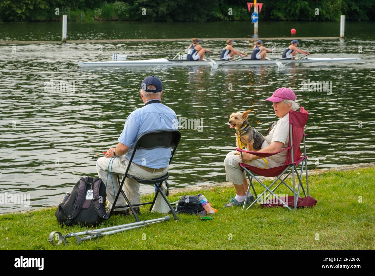 A couple with a small dog watch a race go by from the towpath at Henley Women's Regatta 2023, Henley-on-Thames Stock Photo