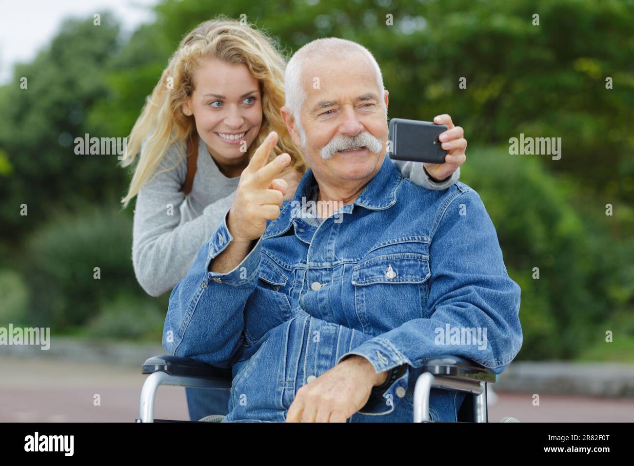 adult daughter taking selfie with disabled father Stock Photo Alamy