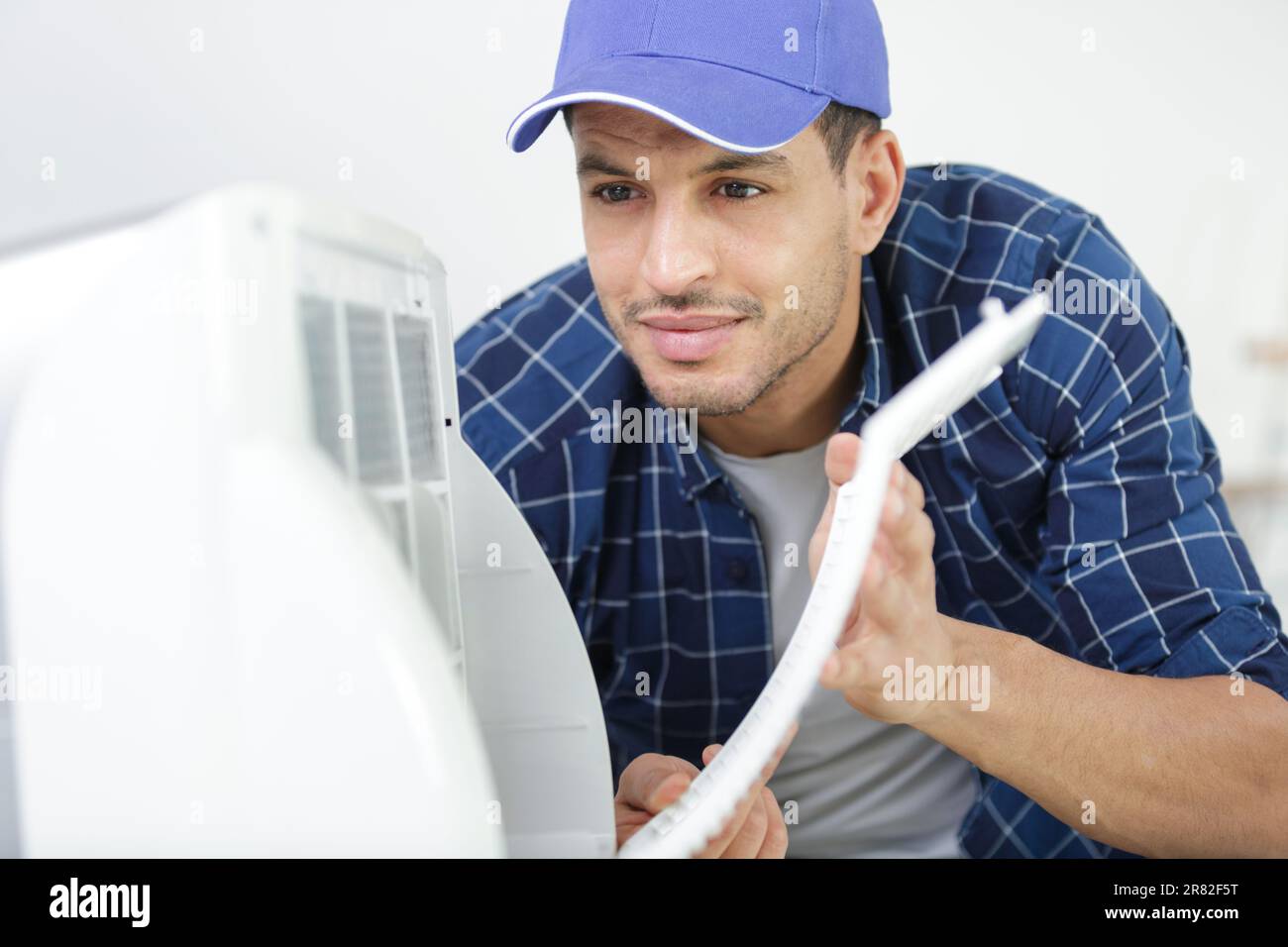 hvac technician working on a capacitor part for condensing unit Stock