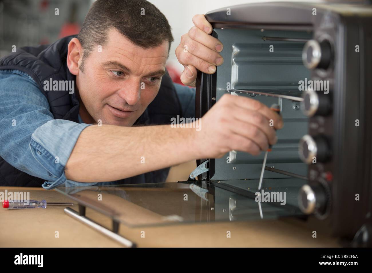 male worker fixing an oven Stock Photo Alamy