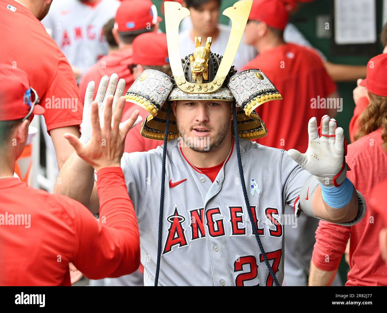 KANSAS CITY, MO - JUNE 18: Los Angeles Angels center fielder Mike Trout  (27) wears the team's Samurai Hat in the dugout after hitting a solo home  run during a MLB game
