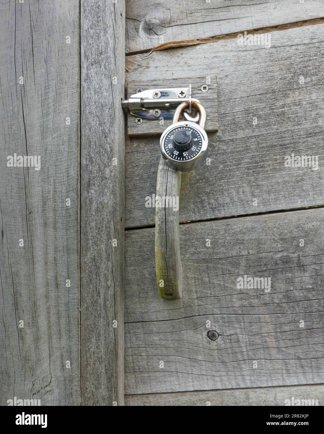 A combination lock on a bolt preventing the opening of a cupboard. Stock Photo
