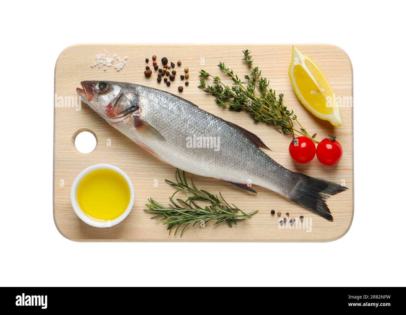 Board with fresh sea bass fish and ingredients on white background, top ...