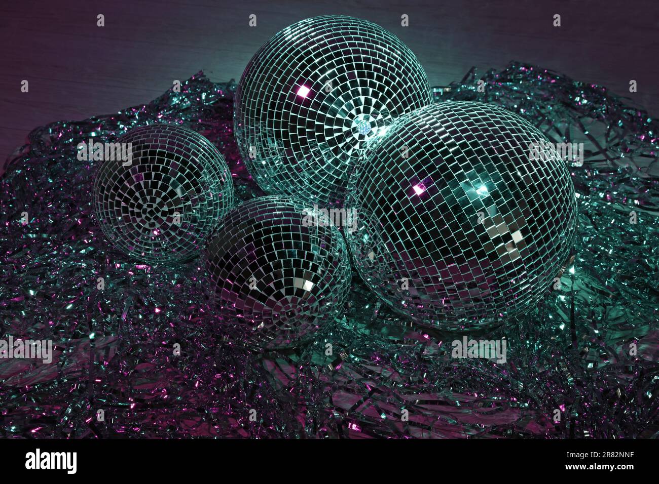 Shiny disco balls and foil fringe curtain indoors, color toned Stock