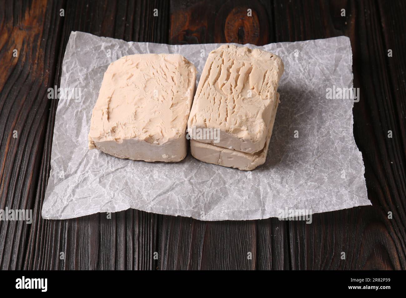 Pieces of fresh compressed yeast on wooden table Stock Photo