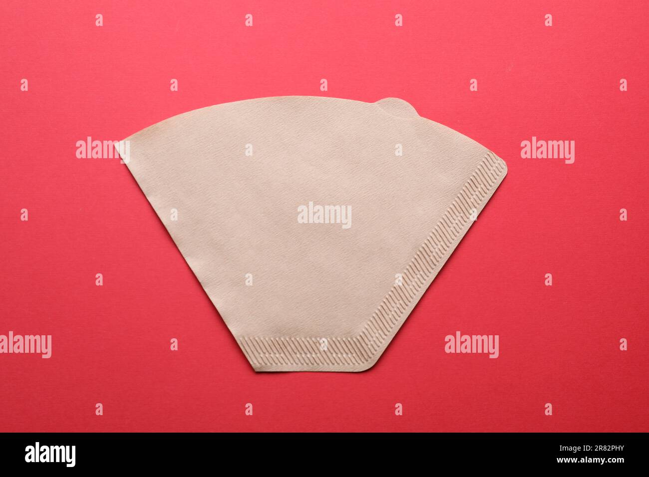Paper coffee filter on red background, top view Stock Photo