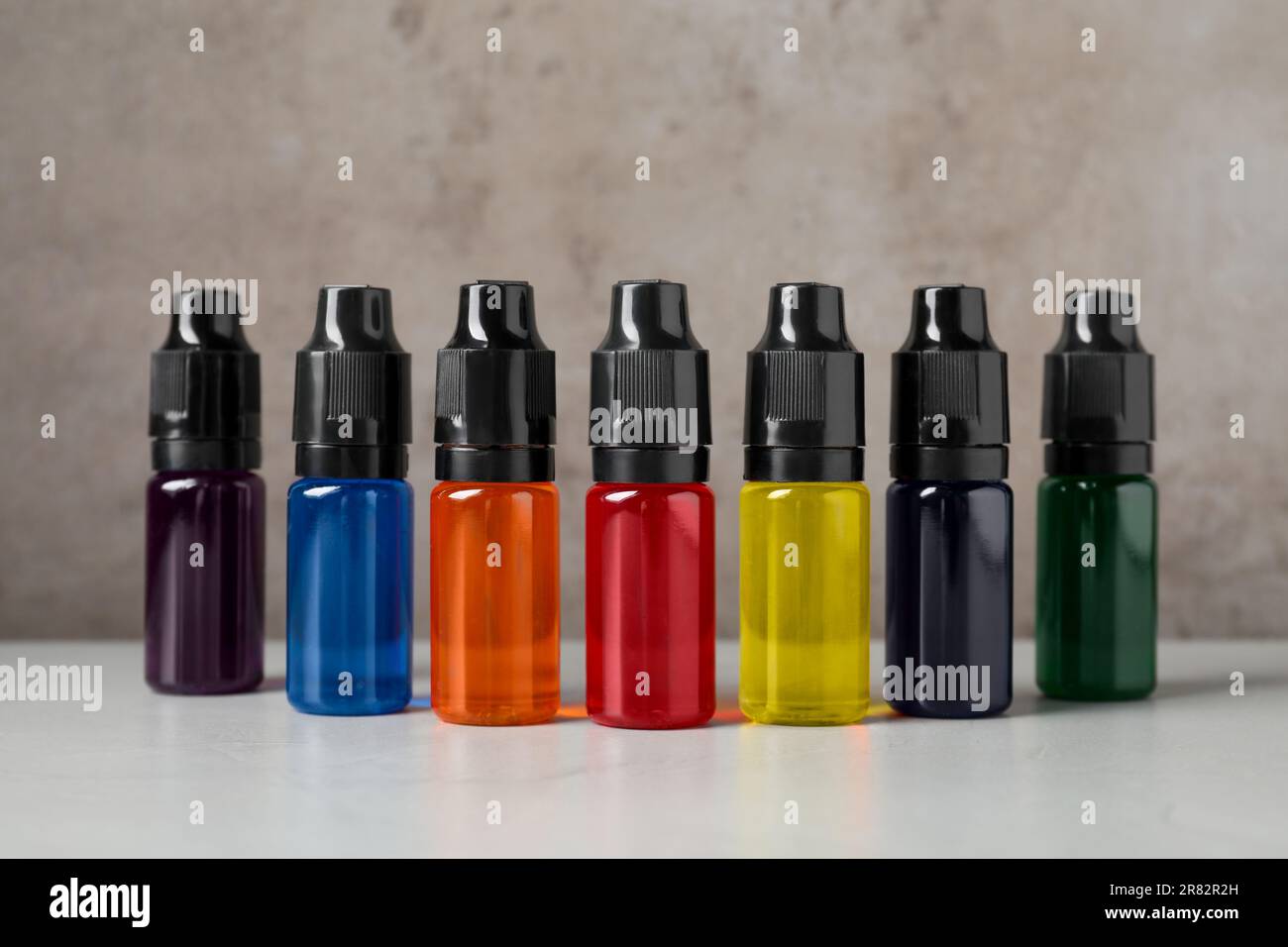 Bottles with different food coloring on white table Stock Photo