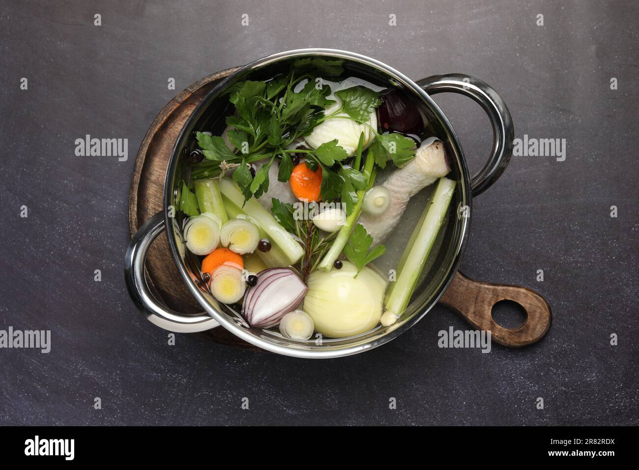 Different ingredients for cooking tasty bouillon in pot on black table