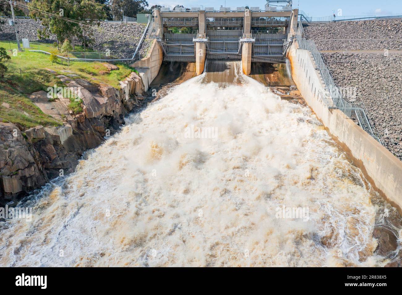 Aerial view over water rushing down a spillway from a weir at Cairn
