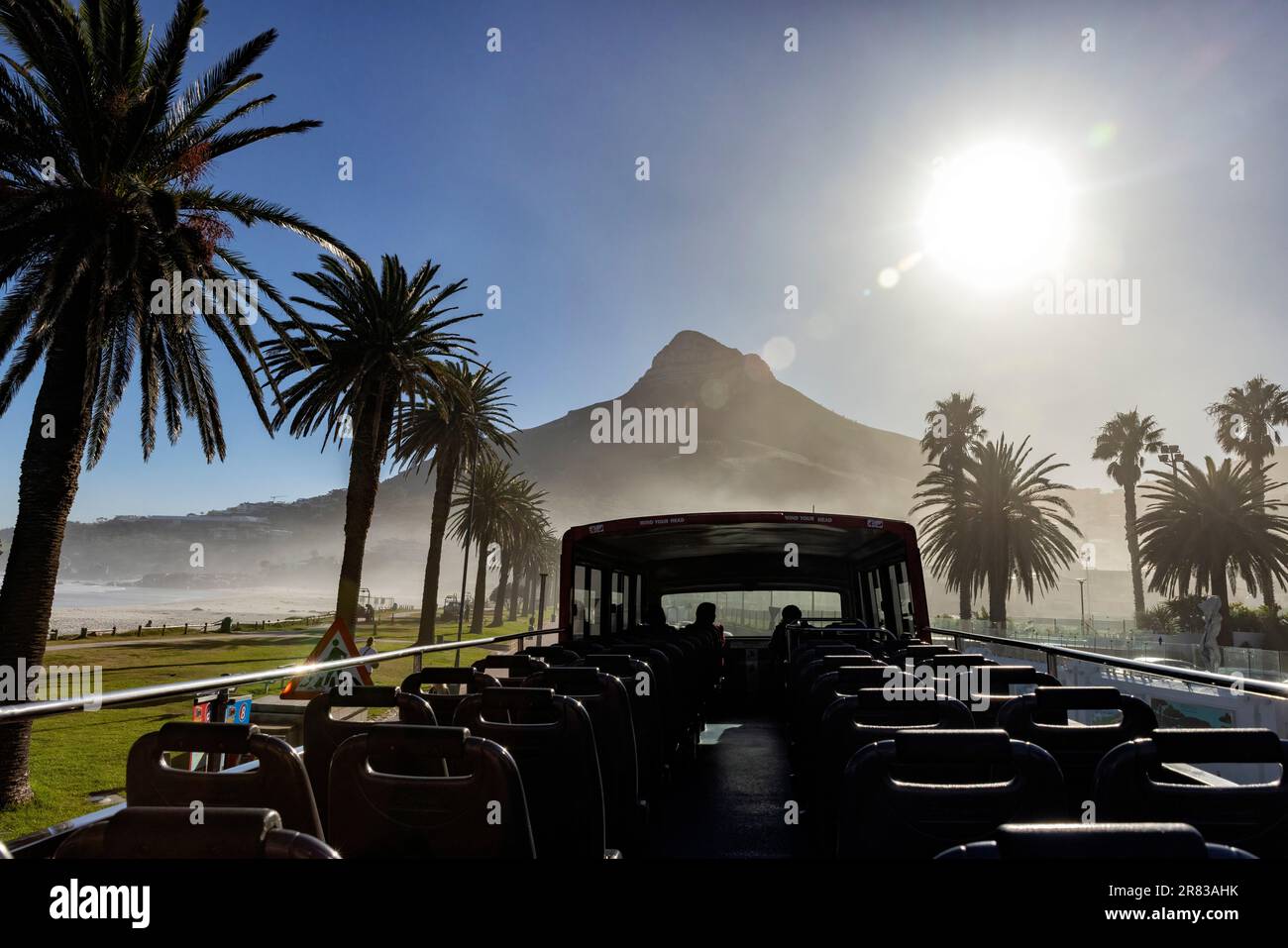 View from Hop On, Hop Off Red Bus on Victoria Road in Camps Bay with Lion's Head mountain in the background - Cape Town, South Africa Stock Photo