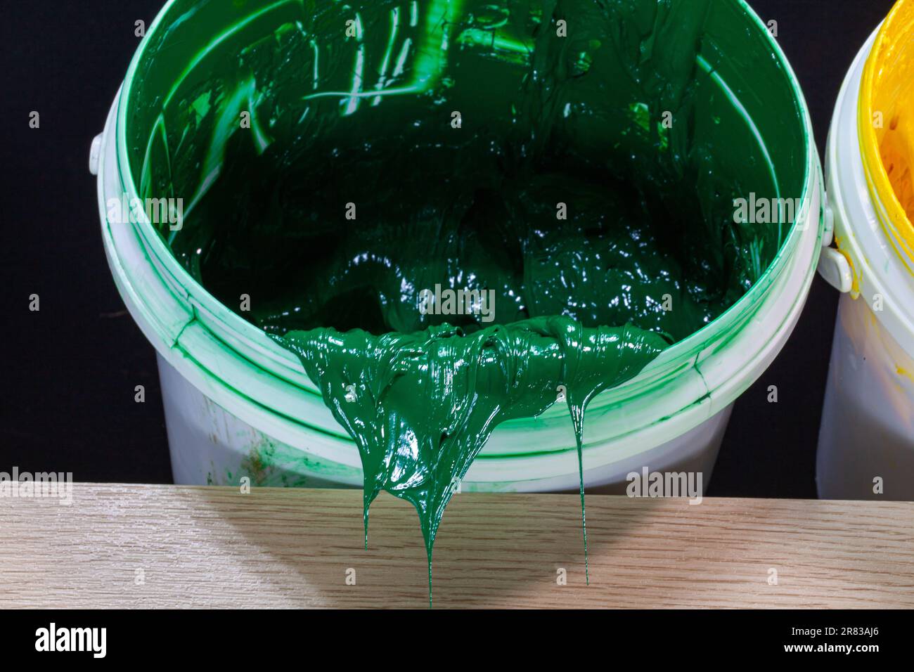 Green paint dripping from white barrel. plastisol ink is used for