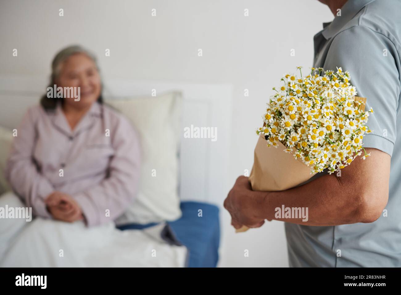 Husband bringing bouquet of flowers to sick wife spending birthday in